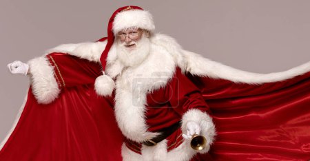Foto de ¡Se acerca la Navidad! Héroe real - Santa Claus con campana de oro y capa roja. - Imagen libre de derechos