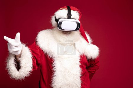 Téléchargez les photos : Père Noël en utilisant cadeau de Noël, jouer sur vr google. - en image libre de droit