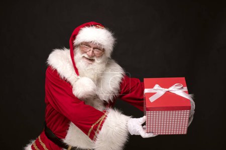 Foto de ¡Se acerca la Navidad! Héroe real - Santa Claus sosteniendo caja de regalo. - Imagen libre de derechos