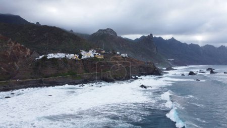 Photo for Panoramic aerial view of wild coastline with big waves on the north coast of the island Tenerife, Spain. Little village in the mountains. Travel destination - Royalty Free Image