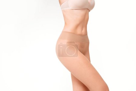 Foto de Foto simple del cuerpo delgado en forma de mujer en medias desnudas básicas. Grabado en estudio. Un montón de espacio de copia. - Imagen libre de derechos