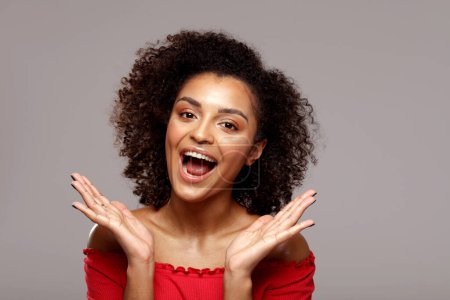 Foto de Mujer afro muy alegre se ríe en voz alta. Gente real emociones y concepto de felicidad. Grabado en estudio. Primer plano retrato de belleza. - Imagen libre de derechos
