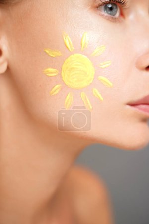 Téléchargez les photos : Soins de la peau. Femme avec de la crème solaire sur le visage. Gros plan photo de beauté. - en image libre de droit