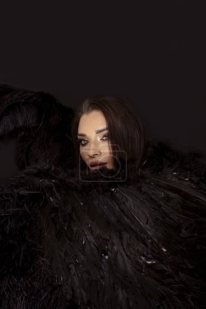 Téléchargez les photos : Portrait de beauté de femme sensuelle comme un ange noir avec des ailes dans des tons sombres. - en image libre de droit