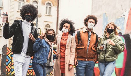 Photo for Happy young group of multiethnic friends having fun in the city after quarantine, wearing face mask. Youth millennial generation friendship. - Royalty Free Image