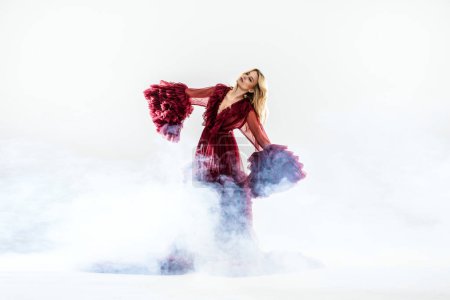 Foto de Mujer rubia de moda posando en hermoso maxi vestido sobre la niebla. Estudio foto. - Imagen libre de derechos