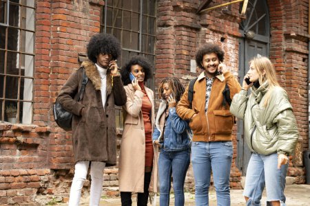 Téléchargez les photos : Groupe multiracial de jeunes parlant par téléphone portable au lieu de parler entre eux. Concept de dépendance à la technologie. - en image libre de droit