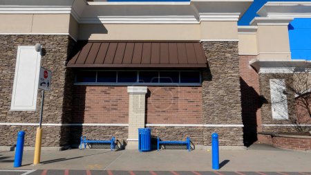 Photo for Grovetown, Ga USA - 12 25 22: Walmart supercenter exterior clear blue sky blue metal seating - Royalty Free Image