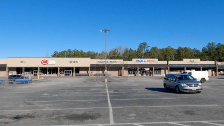 Téléchargez les photos : Augusta, Ga États-Unis - 12 25 23 : Le jour de Noël fermé centre commercial de bande peu de voitures IGA épicerie - en image libre de droit