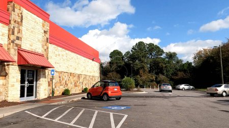 Photo for Augusta, Ga USA - 11 14 22: POV Driving Cook Out fast food restaurant side building small red car - Royalty Free Image