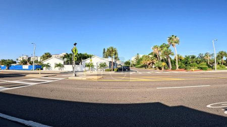 Foto de Treasure Island, Fla Estados Unidos - 08 09 23: Gulf Blvd scenery clear blue sky palm trees and roadway - Imagen libre de derechos