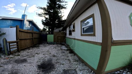 Photo for Treasure Island, Fla USA - 08 09 23: Gulf Blvd scenery green and brown wooden home gravel yard - Royalty Free Image