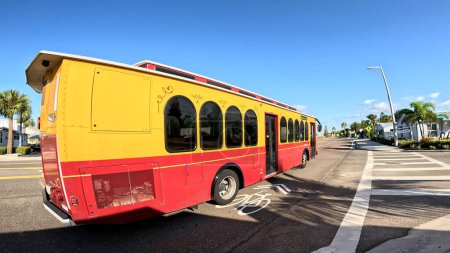 Foto de Treasure Island, Fla Estados Unidos - 08 09 23: Gulf Blvd scenery Yellow and Orange trolley bus passing by - Imagen libre de derechos