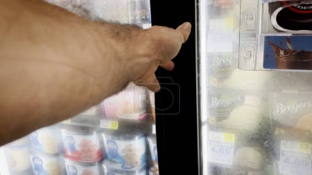 Téléchargez les photos : Hephzibah, Ga États-Unis - 06 15 23 : IGA Grocery store hand opening a freezer glass door - en image libre de droit