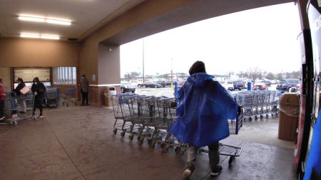 Foto de Augusta, Ga USA - 01 21 22: Walmart super center worker gathering carts - Imagen libre de derechos