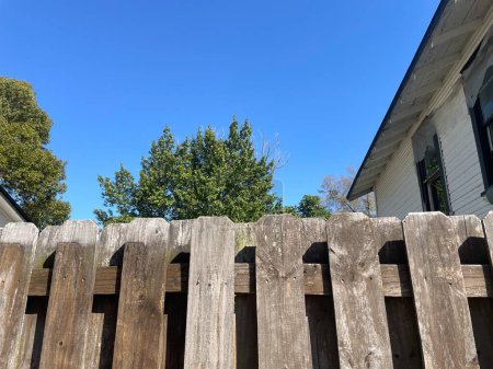 Brown wooden fence shadow box style blue sky summer background