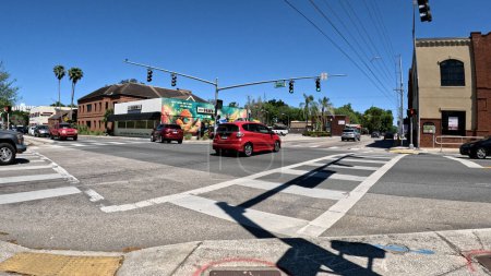 Foto de Lakeland, Fla USA - 03 16 24: Tráfico de coches rojos en una intersección de 4 vías cielo azul claro en Florida Ave - Imagen libre de derechos