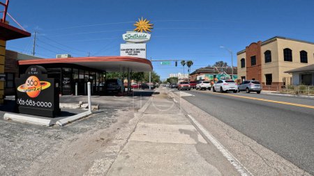 Foto de Lakeland, Fla USA - 03 16 24: Tienda vintage y firmar Tráfico en una intersección de 4 vías cielo azul claro en Florida Ave - Imagen libre de derechos