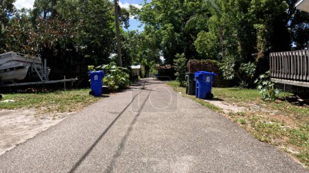 Téléchargez les photos : Lakeland, Fla États-Unis - 04 29 24 : étroite route pavée belles maisons vintage en Floride poubelle jour - en image libre de droit
