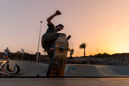 Foto de Joven patina en un parque de skate al atardecer - Imagen libre de derechos