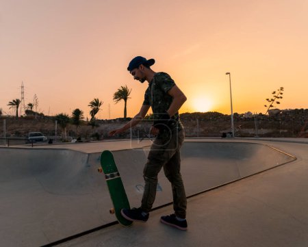 Foto de Joven patina en un parque de skate al atardecer - Imagen libre de derechos
