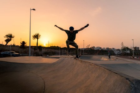 Photo for Young man skates in a skate park at sunset - Royalty Free Image