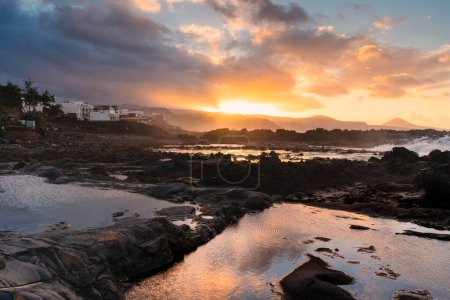 Wellen schlagen bei Sonnenuntergang gegen die Felsen in El Puertillo. Arucas. Gran Canaria. Kanarische Inseln
