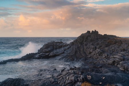 Wellen schlagen bei Sonnenuntergang gegen die Felsen in El Puertillo. Arucas. Gran Canaria. Kanarische Inseln