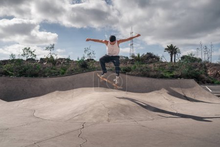 young man with white t-shirt skating in a skate park