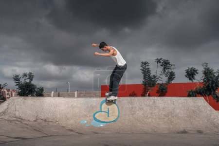 Foto de Joven patina sobre el borde de una rampa en un parque de skate - Imagen libre de derechos