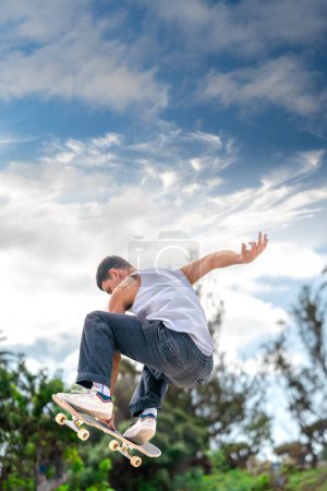 Junger Mann springt mit seinem Skateboard über eine Rampe