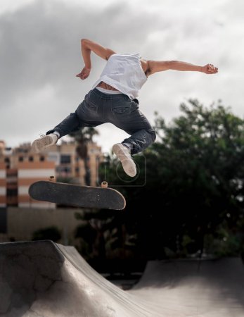 jeune homme sautant une rampe avec son skateboard
