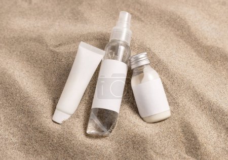 Foto de Cream bottles with blank label on beige sand close up. Package mockup. Natural skincare or SPA product. Facial cosmetics for beauty routine. Zen style with waves on sand, minimal - Imagen libre de derechos