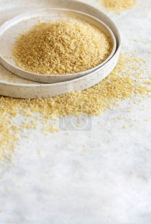 Photo for Raw Dry bulgur wheat grain on a white plate on a table close up, copy space. Vegetarian and Vegan, Mediterranean and Middle Eastern cuisine. Healthy lifestyle - Royalty Free Image