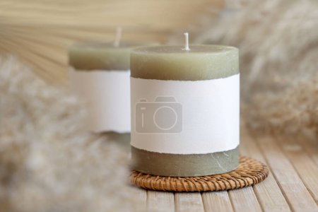 Photo for Candles with blank paper label on wooden table with dried pampas grass, Close up, copy space. Minimal brand packaging mock up. Home decoration, minimal interior, Bohemian or scandinavian styl - Royalty Free Image