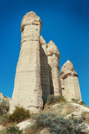 Foto de Formaciones geológicas únicas en el Valle del Amor en Capadocia contra el cielo azul en verano. Zona turística recomendada en Goreme, Nevsehir, Turke - Imagen libre de derechos