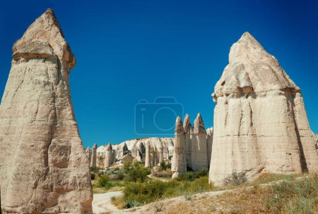 Foto de Formaciones geológicas únicas en el Valle del Amor en Capadocia contra el cielo azul en verano. Zona turística recomendada en Goreme, Nevsehir, Turke - Imagen libre de derechos