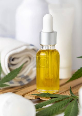 Photo for Dropper bottle with CBD oil and green cannabis leaves and bottles close up in bathroom. Organic healthcare product. Alternative medicine for sleep and relax, CBD cosmetic - Royalty Free Image