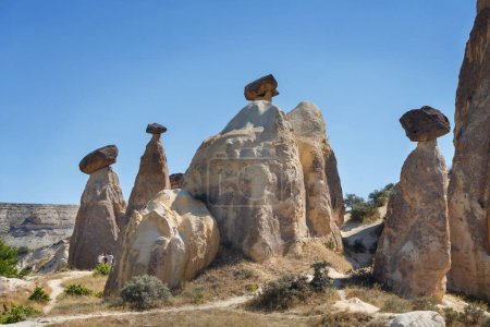Photo for Unique geological rock formations Fairy Chimneys in Cappadocia against blue sky in summer. Popular touristic area in Goreme, Nevsehir, Turke - Royalty Free Image