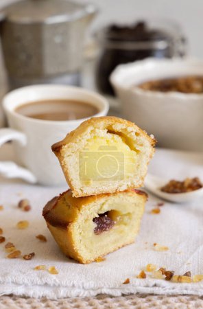Photo for Pasticciotto leccese pastry filled with egg custard cream, typical sweet from Lecce, Italy. Pieces of pasticiotto on a beige napkin, apulian breakfast with coffee prepared, close up - Royalty Free Image