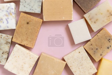 Photo for Beige and brown handmade soap bars on light pink top view, copy space. Natural herbal products for Spa and skin care. Using organic handmade skincare products in everyday routine - Royalty Free Image