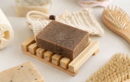 Photo for Organic handmade beige soap bars on soap saver bag near hygiene Items - natural sponges, bamboo toothbrushes and cotton swabs close up on white table. Natural herbal products facecare - Royalty Free Image