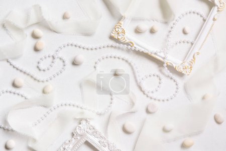 Photo for White frames, pearls, pebbles and silk ribbons top view on a white table. Romantic background for Wedding, Valentines, Spring or Mothers day greetings - Royalty Free Image