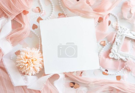 Photo for Paper card near pink decorations, hearts and silk ribbons on white table top view,  mockup. Romantic scene with square blank cards flat lay. Wedding, Valentines, Spring or Mothers day stationery - Royalty Free Image