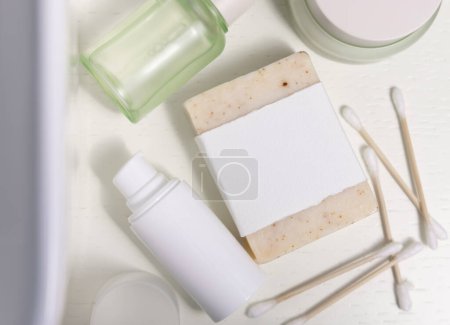 Photo for Soap bar with blank label near personal care products and basin top view, cosmetic packaging mockup, copy space. Natural hygiene products for woman beauty routine - Royalty Free Image