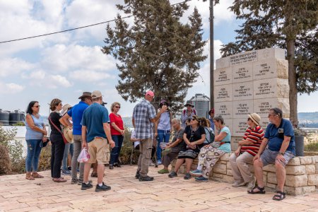 Photo for Tantura, Israel September 12, 2022 Senior citizen's with tour guide at an Independence War of 1948 memorial with the names of fallen fighters. Translation: In remembrance of our dear ones who gave thier souls in the Independence War in this place - Royalty Free Image