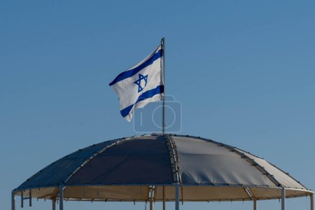 Téléchargez les photos : Israel's flag on top of shade structure at the Dead Sea in Israel. - en image libre de droit