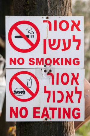 Foto de Haifa, Israel febrero 4, 2023 No fumar, no comer signos en hebreo, árabe e inglés en el Monasterio Carmalita de Muhraqa en el Monte Carmelo, Haifa, Israel. - Imagen libre de derechos