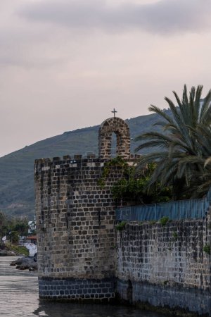 Foto de Torre que parece un castillo y arco con cruz del monasterio ortodoxo griego que está en el agua del mar de Galilea en Tiberíades, Israel. - Imagen libre de derechos