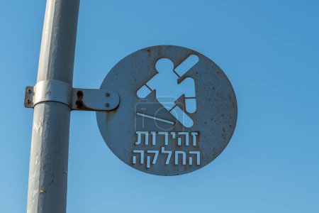 Foto de Tel Aviv, Israel 9 de septiembre de 2022 Precaución resbaladiza recortar letrero de metal que dice "Precaución resbaladiza" en hebreo con el hombre cayendo en Israel. - Imagen libre de derechos